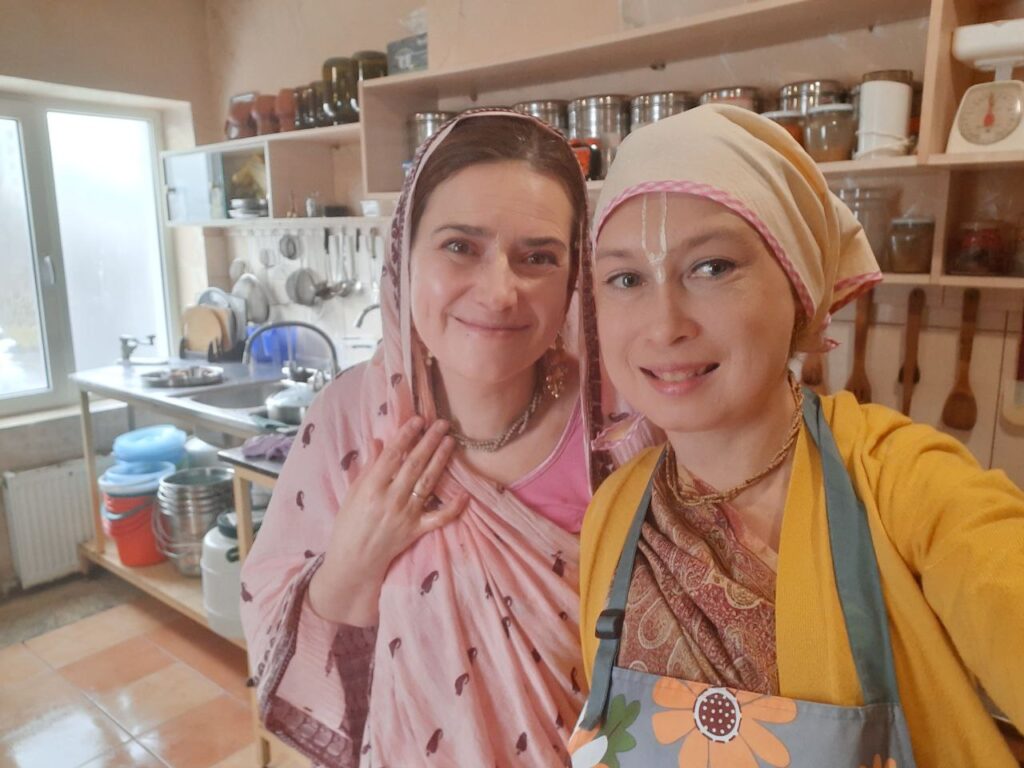 Two devotees in the temple kitchen preparing prasadam