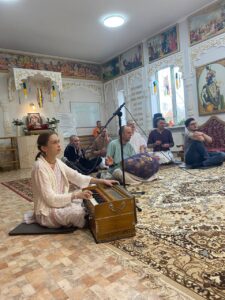 Mataji Raghaletha playing harmonium and leading kirtan in the temple hall